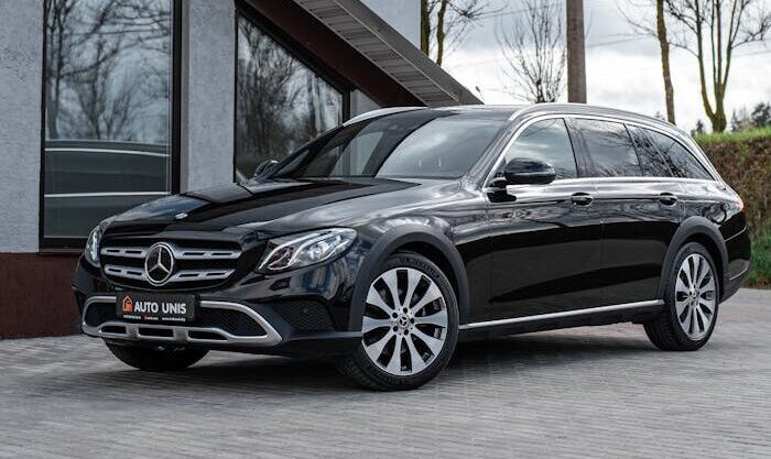 A sleek black Mercedes Benz parked on a paved street, showcasing luxury and elegance.
